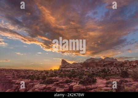 Colorful sunset clouds over the half-dome rock formation at the Green River Overlook in Canyonlands National Park, Utah. Stock Photo