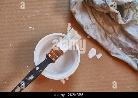 Paint brush on a can of white wall paint Stock Photo