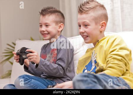 two kids playing video games Stock Photo