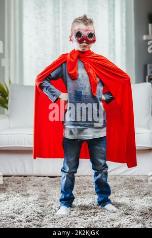 Determined young Super Hero in a colorful red cape Stock Photo