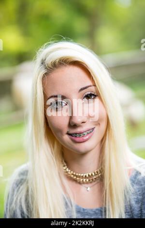 braces on a smiling young blonde woman Stock Photo