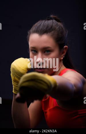 Beautiful young woman boxing in yellow hand wraps Stock Photo