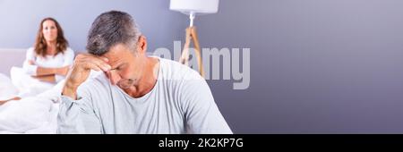 Depressed Man Sitting On Bed Stock Photo