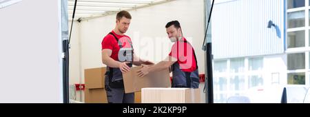 Young Men Stacking The Cardboard Boxes In Moving Truck Stock Photo