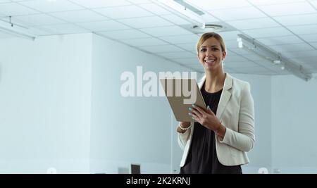 Happy welcoming businesswoman standing holding a tablet-pc Stock Photo