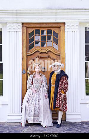 Our humble abode is yours. a royal couple standing in front of their home. Stock Photo