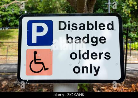 Disabled parking sign that has been altered to say 'Disabled badge olders only' Stock Photo