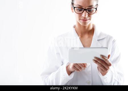 Serious doctor or nurse wearing glasses using a tablet pc Stock Photo