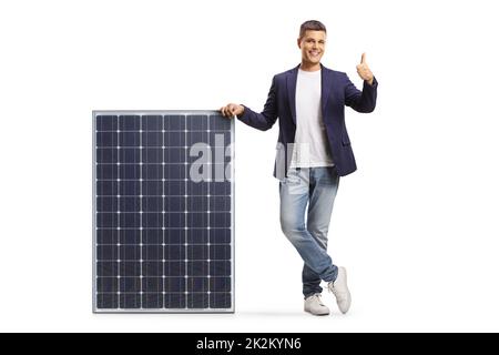 Young man leaning on a solar panel and showing thumbs up isolated on white background Stock Photo