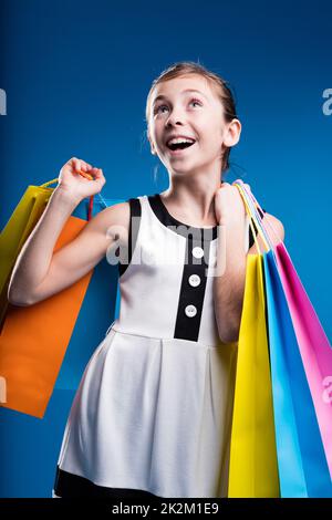 little girl shopping with lots of coloured bags Stock Photo