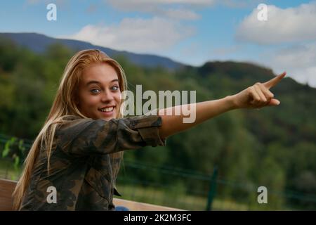 Excited motivated young woman pointing to the sky Stock Photo