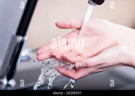 Woman washing her hands under running water Stock Photo