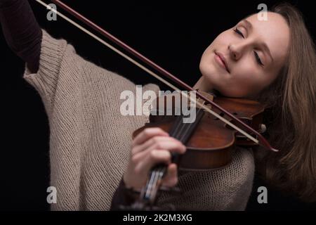 passionate violin musician playing on black background Stock Photo