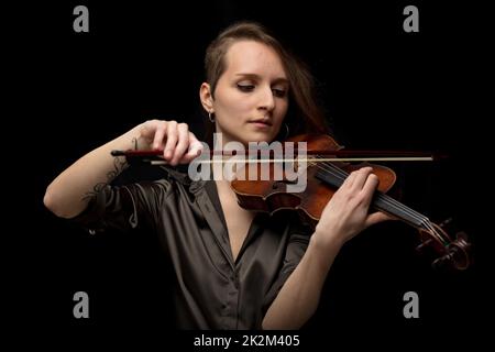 Passionate woman violinist playing classical music Stock Photo