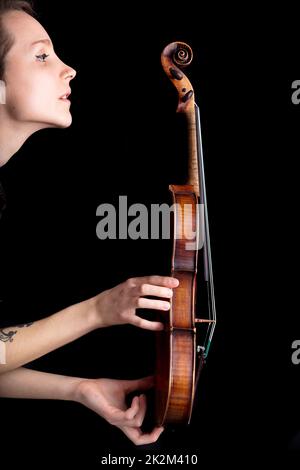 woman profile and violin on black background Stock Photo