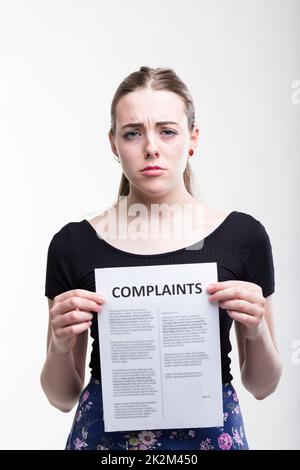 Sad woman holding up a list of complaints Stock Photo