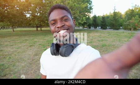 African American man records video on smartphone smiling Stock Photo