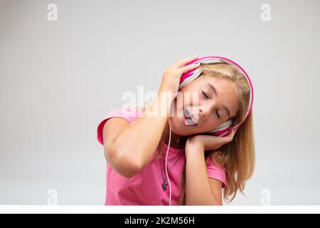 Young blond girl singing along to her music Stock Photo