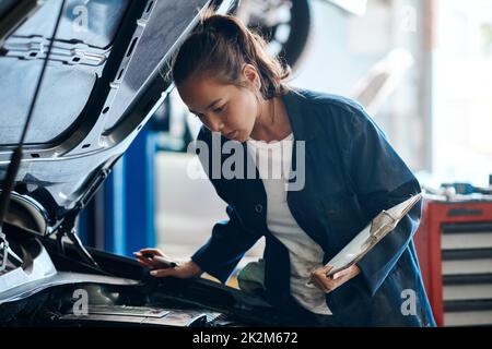 Shell give you the best and least expensive solution for your car problems. Shot of a female mechanic working on a car in an auto repair shop. Stock Photo