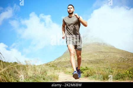 Build a strong mindset and the body will follow. Low angle shot of a sporty young man running outdoors. Stock Photo