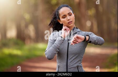 That run did exactly what it was supposed to do. Shot of a woman feeling her pulse while checking her watch. Stock Photo