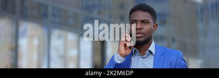 African American bearded man calls to colleague on phone Stock Photo