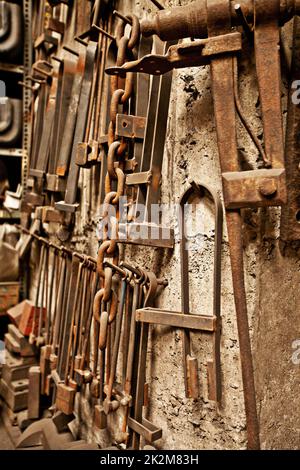 Vintage tools for the vintage craftsman. A range of well-used tools hanging on a textured wall. Stock Photo
