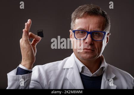 Scientist or forensics expert holding up an SD Card Stock Photo