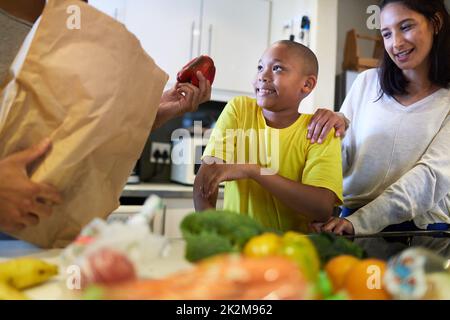 What's for supper. Shot of a family unpacking the groceries in the kitchen at home. Stock Photo