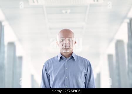 Senior businessman with a deadpan serious expression Stock Photo