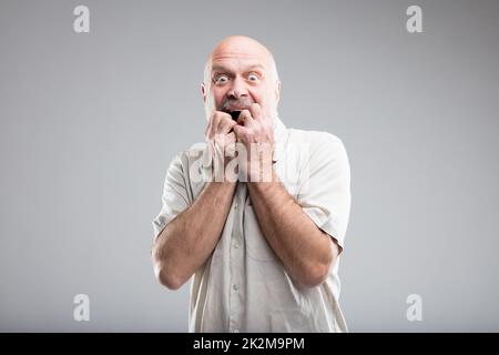 scared man biting his nails because of fear Stock Photo