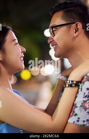I want you this close to me. Shot of a happy young couple spending the night out in the city. Stock Photo
