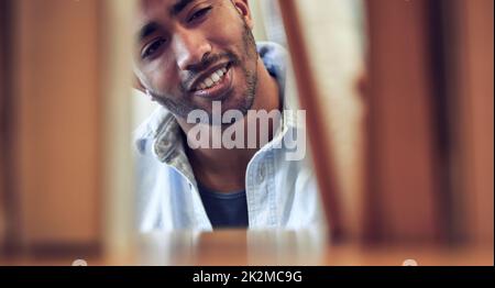 Advance your knowledge, transform your life. Shot of a young man choosing a book to read from a library at college. Stock Photo