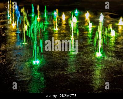 Illuminated waterspout fountain at night Stock Photo - Alamy