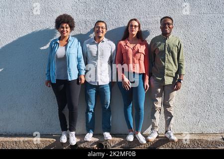 We all have a place in our community. Shot of a group of young people standing together against an urban background outdoors. Stock Photo