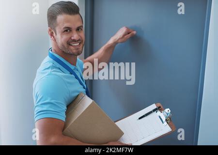 He always delivers on time. Portrait of a courier knocking on a door to make a delivery. Stock Photo