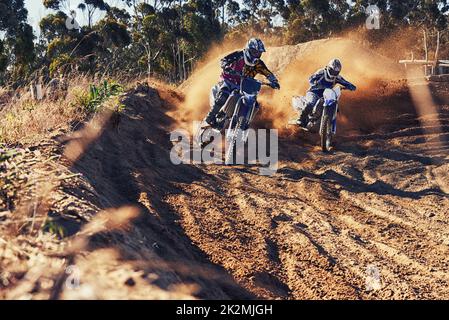 Time to rip up this track. Shot of two motocross racers in action. Stock Photo