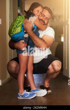 The best part of going to school is coming home. Shot of an adorable little girl hugging her father after coming home from school. Stock Photo