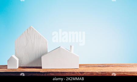 Small white wooden houses on a blue background. Private housing concept Stock Photo