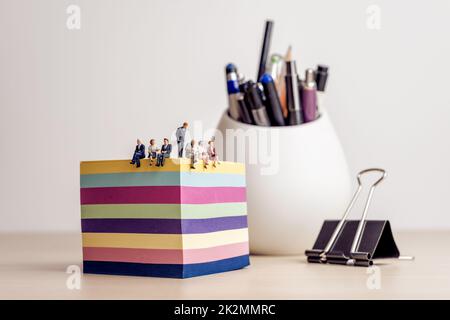 Businesspeople meeting in a miniature office Stock Photo
