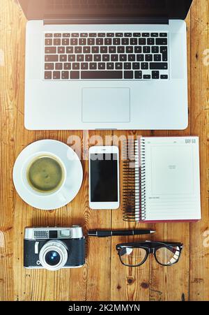 The creatives essentials. Cropped shot of a creative businesspersons desk with a laptop, camera, smartphone and other objects. Stock Photo