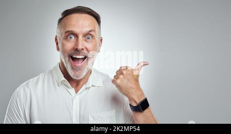 Im eager to support the cause. Studio portrait of a mature man showing thumbs up against a grey background. Stock Photo