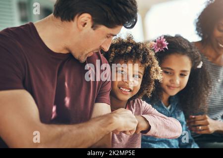 Keep the family close. Shot of a beautiful young family bonding and spending time together at home. Stock Photo