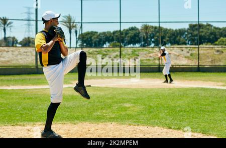 Putting his pitching skills to work. Full length shot of a handsome young baseball player pitching a ball during a match on the field. Stock Photo