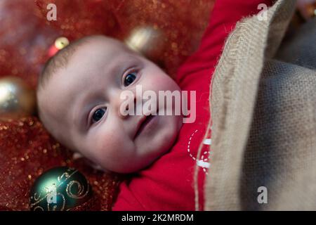 Happy little Christmas baby with colorful baubles Stock Photo