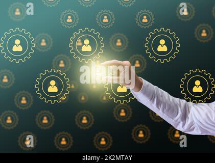 office workers icons in round gears and male hand. Concept of hierarchy in the company, corporate ethics of employees. Recruitment of personnel Stock Photo
