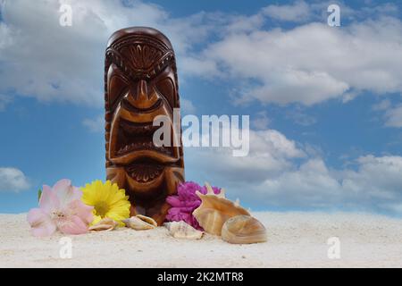 Antique Wooden Mask From Hawaii on Beach With Flowers and Blue Sky Stock Photo