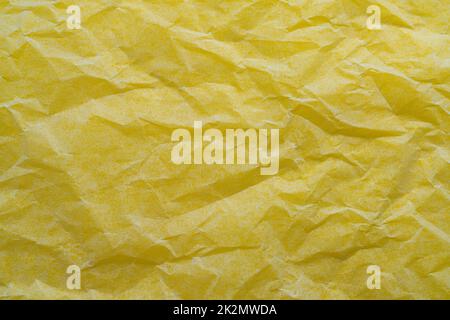 crumpled paper on a yellow surface Stock Photo