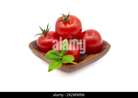 Cherry tomatoes with basil leaves over a white Stock Photo