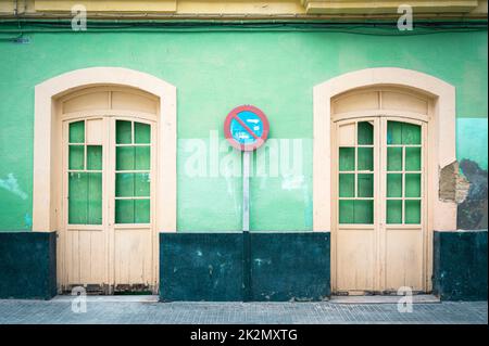An old building painted green with cream doors in Cadiz Spain showing the traditional urban architecture in the old part of the city. Stock Photo